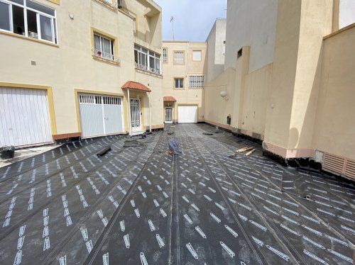 Impermeabilización y pavimentación con hormigón impreso de plazoleta de residencial en Calle Real del Barrio Alto (Almería)